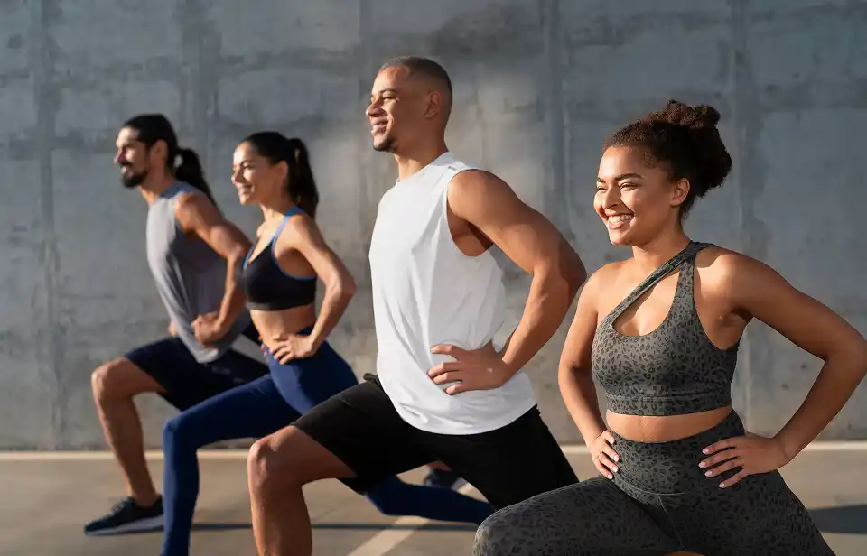 Alunos contentes se alogando após uma aula de Pilates 